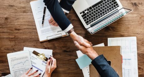 Legal & Compliance Skills professionals shaking hands and working at a large desk