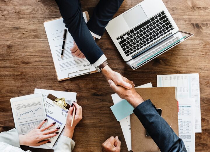 Legal & Compliance Skills professionals shaking hands and working at a large desk