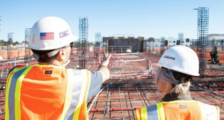 two individuals wearing PPE on site, discussing workplace safety skills