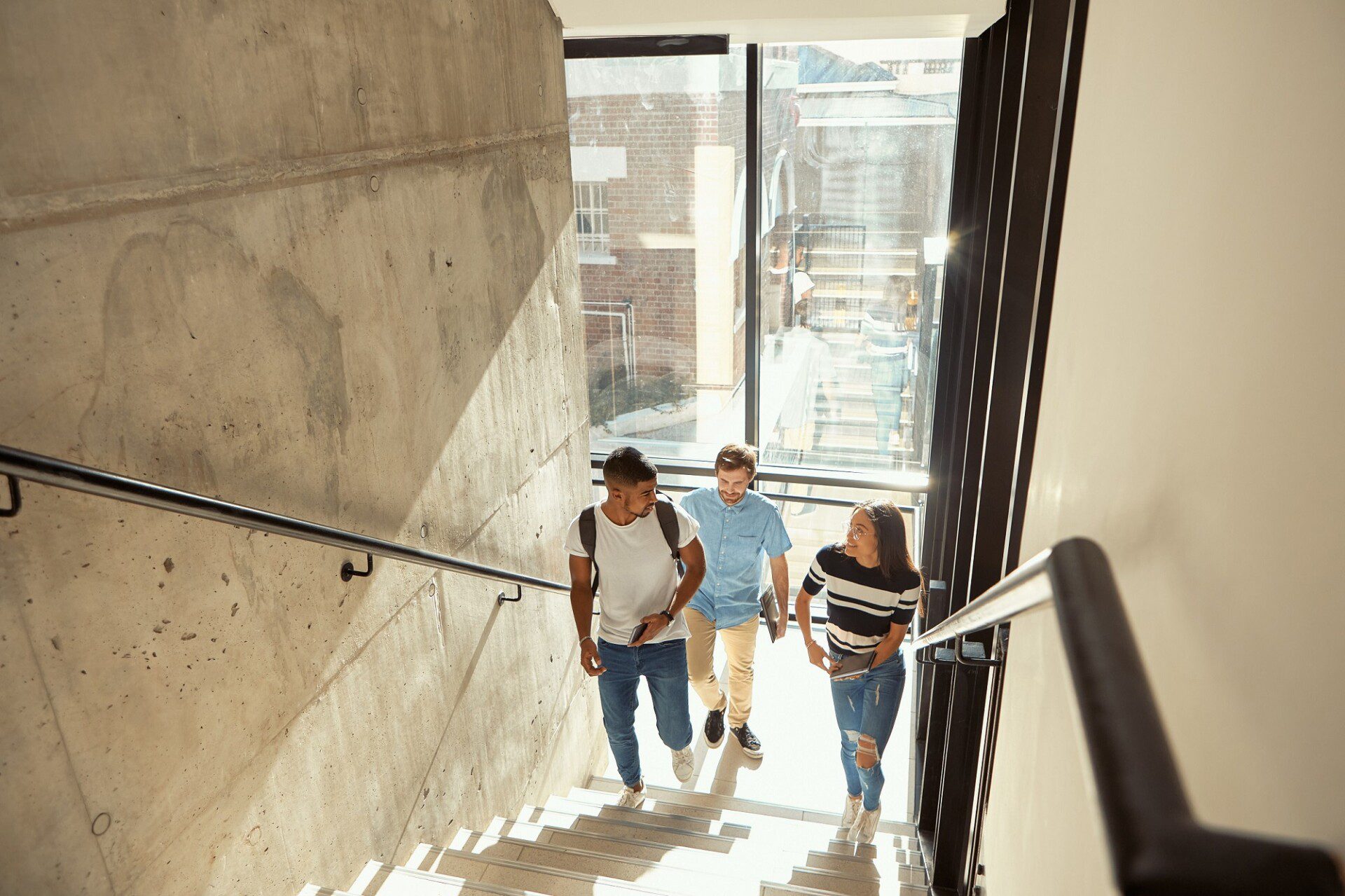 Shot of a group of young businesspeople walking upstairs in a modern office