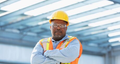 Construction Worker Considering Building Safety Regulations 2010 whilst crossing his arms.